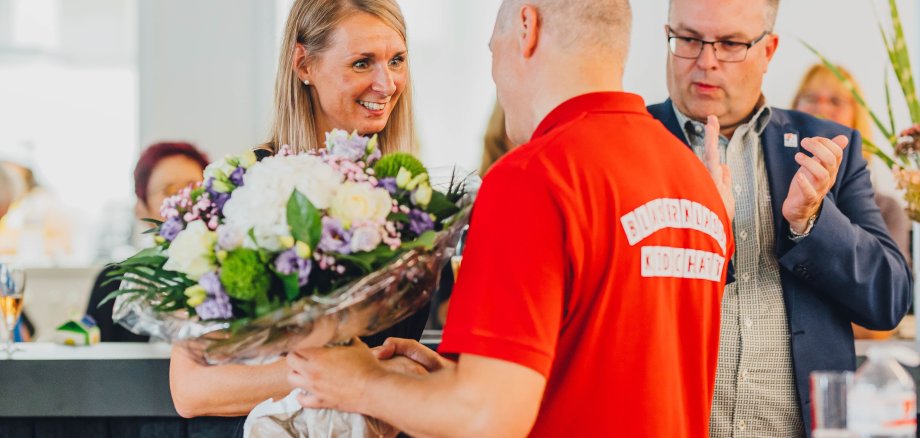 Mann überreicht Frau einen Blumenstrauß.